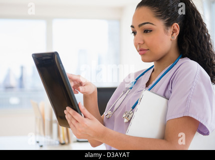 Hispanic nurse using tablet computer in hospital Stock Photo