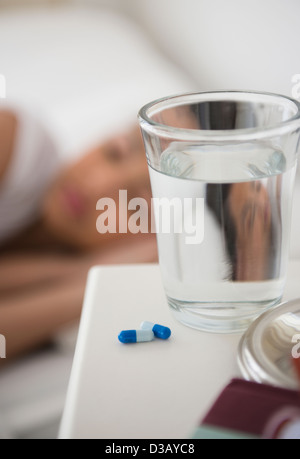 Close up of pills and water on bedside table Stock Photo