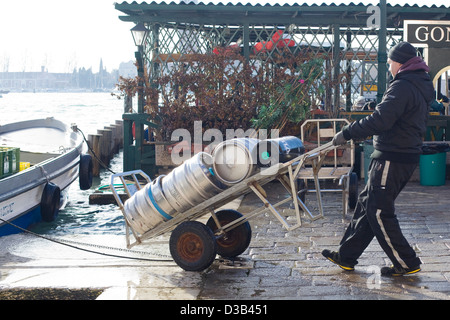 Man Bringing Ale Kegs off a boat in to Venice Stock Photo