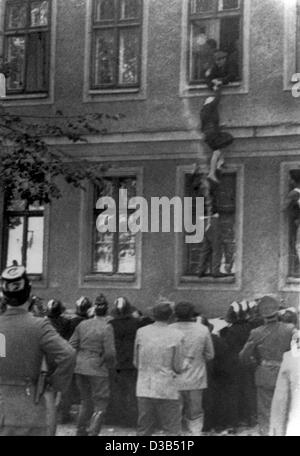 (dpa files) - An elderly lady, assisted by two men, climbs out of a window of a house to get to West Berlin, in Bernauer Strasse, East Berlin, September 1961. The house is built on East German territory on the demarcation line of the Soviet Sector, while the Bernauer Street belonged to West Berlin.  Stock Photo