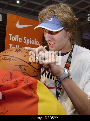 (dpa) - German national basketball player Dirk Nowitzki signs autographs after his arrival at the airport in Frankfurt, 10 September 2002. The German team won bronze during the basketball world championships in Indianapolis. Stock Photo