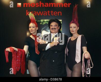 (dpa files) - Rudolph Moshammer, eccentric German fashion designer, presents with two models with cranky hairstyles his latest tie collection of glaring red and soft pink ties during a men's wear fashion show in Cologne, 13 July 2001. Stock Photo