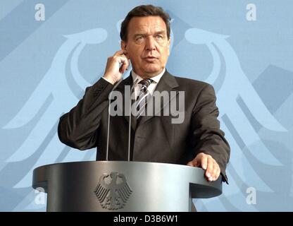 (dpa) - Chancellor Gerhard Schroeder comments on the plans of the so-called Hartz Commission to reduce unemployment in Germany in front of the Federal Eagle logo in the chancellor's office in Berlin, 9 August 2002. Stock Photo