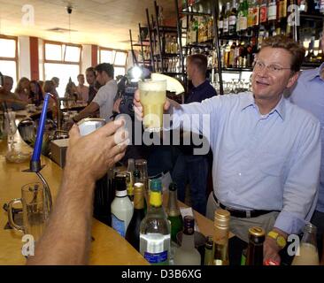 (dpa) - Guido Westerwelle, Chairman of the German liberal party FDP, serves as a barmixer to promote his election campaign programme in a student's cafeteria in Greifswald, Germany, 7 August 2002. For five weeks Westerwelle will tour the country in his trailer, the so called 'Guidomobil'.