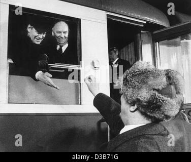 (dpa files) - Erich Honecker (R), East German political leader, gives a lollipop to German President Helmut Schmidt (L) at his departure at the train station in Guestrow, East Germany, 13 December 1981. Next to Schmidt is Federal Minister Egon Franke. Schmidt paid a three day visit to the German Dem Stock Photo