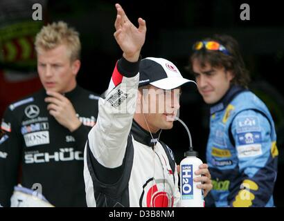 (dpa) - British Formula One driver Jenson Button of BAR Honda (C), Finnish Kimi Raikkonen of McLaren Mercedes (L) and Spanish Fernando Alonso of Renault greet spectators after the qualifying session at the Silverstone circuit, UK, Saturday, 09 July 2005. The British Grand Prix will take place at the Stock Photo