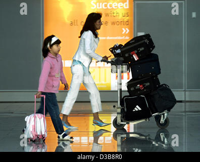 (dpa) - Mother and daughter rush through the airport in Duesseldorf, Germany, 05 July 2005. Children, who are not of school age yet, are able to take off one day before school holidays begin. On the last day, Wednesday 06 July 2005, school reports are issued. Stock Photo