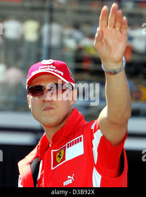 (dpa) - German Formula One driver Michael Schumacher of Ferrari greets spectators at the Formula One race track in Silverstone, England, 10 July 2005. Stock Photo