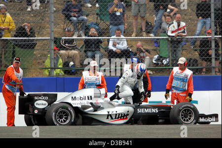 (dpa) - Finnish Formula One driver Kimi Raikkonen (R) of McLaren Mercedes leaves his car during the practice session at the Silverstone circuit, UK, Saturday, 09 July 2005. The British Grand Prix will take place at the Silverstone circuit on Sunday, 10 July. Stock Photo