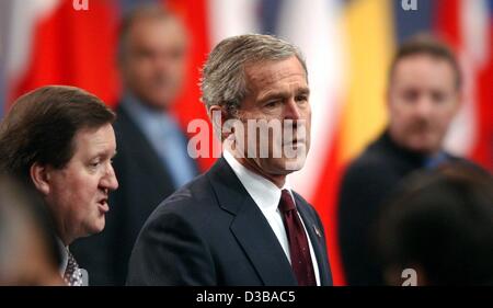 (dpa) - US President George W. Bush (C) and George Robertson (L), NATO Secretary General, arrive at the second day meeting of the NATO summit in Prague, Czechia, 22 November 2002. The main issue of the two-day summit was the transformation of the alliance from the Cold War-era to the post-September  Stock Photo
