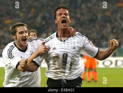 (dpa) - German goal scorer Fredi Bobic (R) jubilates with his team mate Torsten Frings during the international friendly soccer match Germany against Netherlands in Gelsenkirchen, Germany, 20 November 2002. Holland went on to win 3-1. It is Germany's first defeat since the World Cup final. Stock Photo