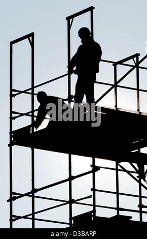 (dpa) - Two construction workers are pictured on scaffolding, Cottbus, 6 November 2002. The building industry has been in recession for a couple of years. Still a major problem is illegal employment. Stock Photo
