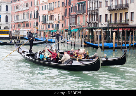 Two Gondolas Traditional Venetian rowing boat taking Tourists for a trip down the  Grand Canal Venice Italy Stock Photo