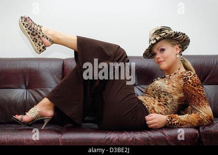 (dpa) - Lying on a sofa, model Diana presents two different shoes of the spring summer 2003 season at the German Institute for Shoe Fashion in Offenbach, Germany, 21 January 2003. Stock Photo