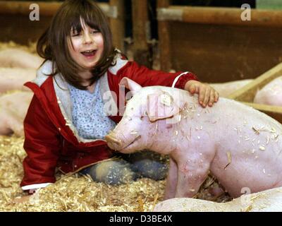 (dpa) - Five-year-old Lucy plays with the pigs at the Green Week ('Gruene Woche') trade fair in Berlin, 21 January 2003. The Green Week is an international trade fair for farming and gardening. 1,600 exhibitors from 55 countries will come to the fair, which runs through 26 January 2003. Stock Photo