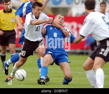 (dpa) - German midfielder Bernd Schneider (L) fights for the ball with Faroese midfielder Julian Johnsson during the qualifying match for the 2004 European Championships in Torshavn, Faeroe Islands, 11 June 2003. Germany won the second leg game 2-0. Stock Photo