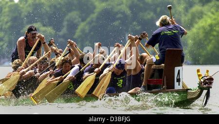 (dpa) - The crew of a dragon boat paddles to the rhythm of the drum and the shouting of the cox during the dragon boat regatta on a lake in Hanover, Germany, 7 June 2003. 110 teams registered for the race which took place for the ninth time. The race originated in China some 2,000 years ago when, ac Stock Photo