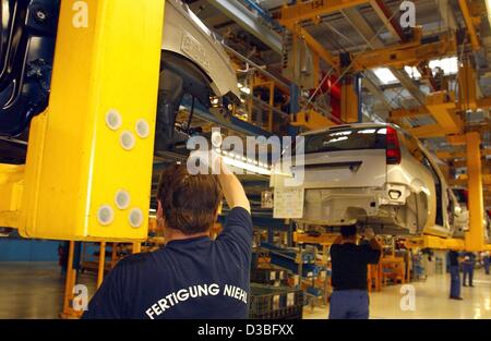 (dpa) - Employees of Ford car manufacturer work on the production of a Ford 'Fiesta' in the Ford production plant in Cologne, Germany 23 June 2003. The factory employs 20,800 workers from 57 countries. Ford has based its German heaquarters in Cologne since 1931 but operates further manufacturing pla Stock Photo