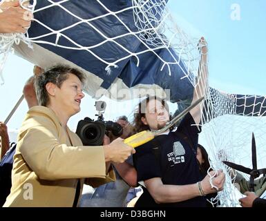 (dpa) - Renate Kuenast (Green Party), German Minister for Consumer Protection, Food and Agriculture cuts, as a symbolic gesture, a net with a pair of scissors which has trapped a cardboard whale before the start of the 55th International Whaling Commission (IWC) conference in Berlin, 16 June 2003. T Stock Photo