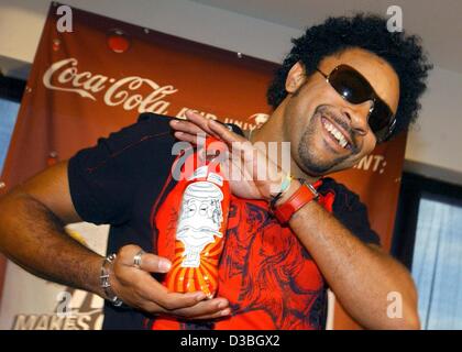 (dpa) - US reggae singer Shaggy presents a coca-cola bottle with his design at a press conference in Berlin, Germany, 13 June 2003. The bottle is covered with a motive the singer created. In cooperation with Universal Music Coca-Cola provides its 0,5 litre bottles with motives designed by Shaggy and Stock Photo