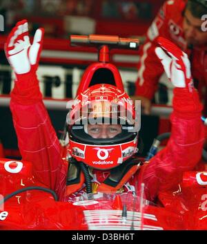 (dpa) - German formula one champion, Michael Schumacher (Ferrari), slides into his formula one racing car before he starts to the qualifying training round during the Austrian grand prix on the A1-Ring racetrack in Zeltweg, Austria, 16 May 2003. The Austrian grand prix, which is the sixth race leadi Stock Photo