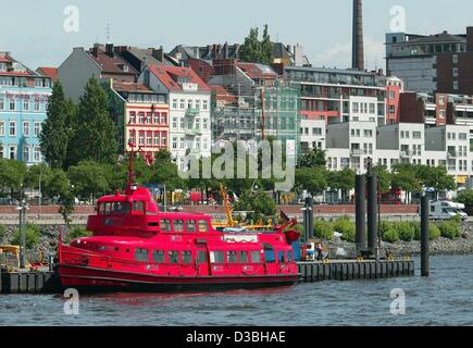 (dpa) - A view across the River Elbe towards the Hafenstrasse in Hamburg, Germany, 6 June 2003. A red boats docks at the pier near the road. Stock Photo