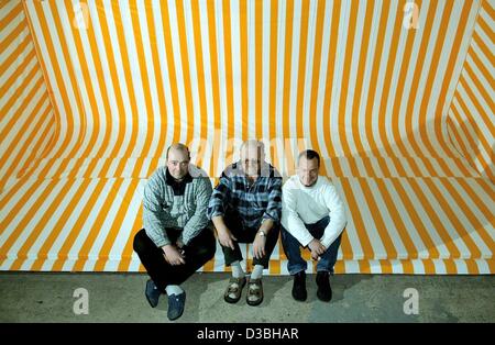 (dpa) - Senior-director Peter (C) and his two sons Frank (L) and Lars sit in an oversize roof of a beach chair in the beach chair factory Eggers in Moelln, Germany, 16 April 2003. The family business has existed since 1772. Since 1948, roofed wicker beach chairs have been produced. Presently, the fa Stock Photo