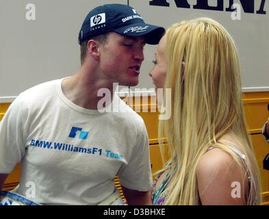 (dpa) - The German formula one pilot Ralf Schumacher of the BMW-Williams team and his wife Cora kiss each other ahead of the Grand Prix of Monaco in Monte Carlo, 1 June 2003. Stock Photo