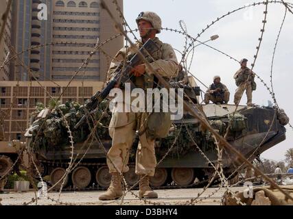 (dpa) - US army soldiers stand guard in front of the main entrance of Hotel Palestine in Baghdad, 15 April 2003. Some 300 Iraqis gathered outside the hotel, where the US marines have set up an operations base, for a third straight day of protests against the US occupation. Most of the international  Stock Photo