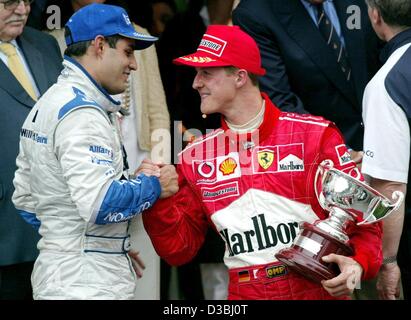 (dpa) - Colombian formula one pilot Juan Pablo Montoya (L) congratulates third-placed Michael Schumacher (R, Ferrari) after the Grand Prix of Monaco in Monte Carlo, 1 June 2003. Montoya finishes first and celebrates the first victory of BMW Williams this season. Stock Photo