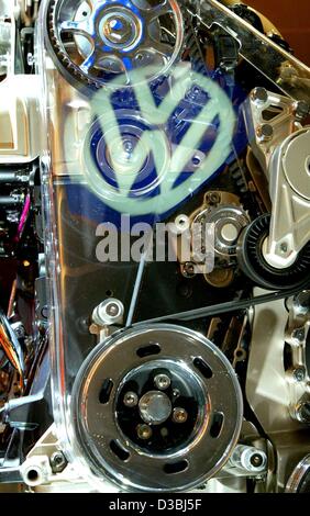 (dpa) - The logo of German Volkswagen (VW) car manufacturers is reflected on the glass cover of a VW New Beetle engine, during the VW general meeting in Hamburg, Germany, 24 April 2003. The German automotive giant is off to a slow start in 2003 and is bracing for operating results which will fall sh Stock Photo