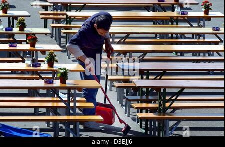 (dpa) - An employee sweeps the benches and tables in a beer garden in Duesseldorf, Germany, 14 April 2003. Stock Photo