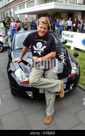 (dpa) - German singer Dieter Bohlen of the duo Modern Talking sits on the hood of a black Ford Streetka, already signed with the autographs of a number of stars, at the Ford factory in Cologne, Germany, 27 May 2003. The car will be auctioned off by Unicef this summer, the donations will go to childr Stock Photo