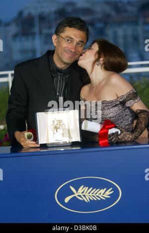 (dpa) - The Turkish film director Nuri Bilge Ceylan poses with his Grand Prix award which he received for his film 'Uzak' ('Distant') and his wife Ebru congratulates him with a kiss, during the closing ceremony of the 56th Cannes film festival in Cannes, France, 25 May 2003. Stock Photo