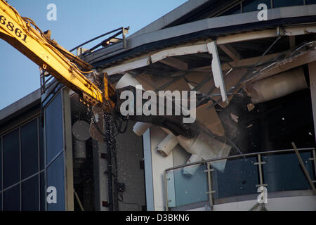 Bournemouth, UK 15 February 2013. The bulldozers start tearing down the glass front of one of the most hated buildings in the UK, the Imax complex building on Bournemouth seafront. Once demolished, the site will be turned into an open-air events arena, ready for the summer season. Stock Photo