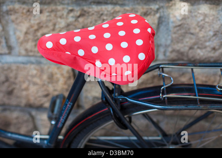 Doted bike seat against wall, side view. Stock Photo