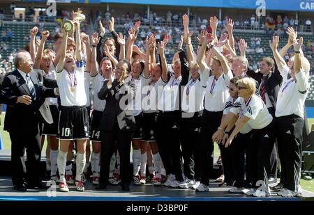 (dpa) - German team captain Bettina Wiegmann (2nd from L) holds up the world cup trophy while she poses with her team after winning the final of the Women's Soccer World Cup opposing Germany and Sweden in Carson/California, USA, 12 October 2003. On the left the President of the world soccer federati Stock Photo