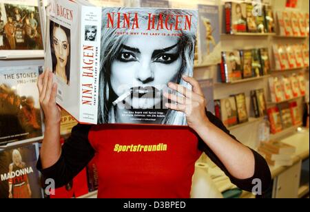 (dpa) - A visitor reads the autobiography of German pop icon Nina Hagen, at the market stand of publisher Schwarzkopf & Schwarzkopf at the Book Fair in Frankfurt, 8 October 2003. The world's biggest book fair will run from 7 through 13 October with 6,413 exhibitors from 104 countries. Stock Photo