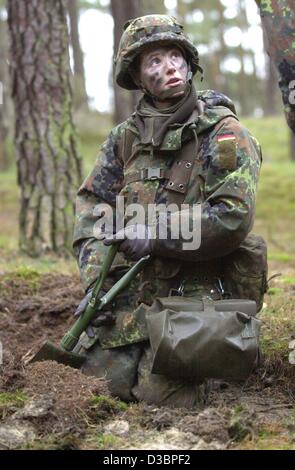 (dpa files) - A female soldier with a camouflaged face digs a hole during a training on the Bundeswehr training grounds in Havelberg, Germany, 24 January 2001. Although women have been formally allowed to join the German armed forces for about two and a half years, there are still few women in the a Stock Photo