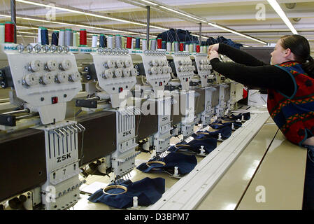 (dpa) - A female employee of t-shirt and tennis clothing producer Trigema threads yarn at machines which stitch the company logo onto fabric in Burladingen, Germany, 16 December 2004. Trigema which has about 1,200 employees has been making profits for the last 35 years. Executive Director Wolfgang G Stock Photo