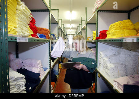 (dpa) - A female employee of t-shirt and tennis clothing producer Trigema walks through the storage in Burladingen, Germany, 16 December 2004. Trigema which has about 1,200 employees has been making profits for the last 35 years. Executive Director Wolfgang Grupp took the company over from his fathe Stock Photo