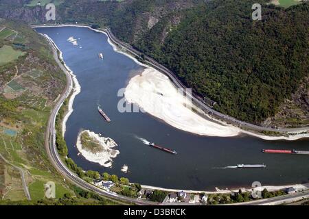 (dpa) - Cargo ships pass two sandbanks on the river Rhine near Oberwesel, Germany, 30 September 2003. German rivers currently have very low water levels due to the dry and sunny wheather in the past weeks. Barges must reduce their cargo to be able to travel the Rhine. Stock Photo