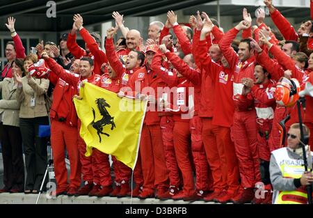 (dpa) - Team Ferrari salutes German Formula One world champion Michael Schumacher after he passes the chequered flag to win the US Grand Prix in Indianapolis, 28 September 2003. Schumacher won ahead of Finland's Kimi Raeikkoenen of McLaren-Mercedes and fellow German Heinz-Harald Frentzen of Sauber.  Stock Photo