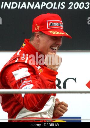 (dpa) - German Formula One world champion Michael Schumacher celebrates on the podium after driving his Ferrari to victory in the US Grand Prix in Indianapolis, 28 September 2003. Schumacher won ahead of Finland's Kimi Raikkonen of McLaren-Mercedes and fellow German Heinz-Harald Frentzen of Sauber. Stock Photo