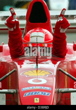 (dpa) - German Formula One world champion Michael Schumacher celebrates after driving his Ferrari to victory in the US Grand Prix in Indianapolis, 28 September 2003. Schumacher won ahead of Finland's Kimi Raeikkoenen of McLaren-Mercedes and fellow German Heinz-Harald Frentzen of Sauber. The US grand Stock Photo