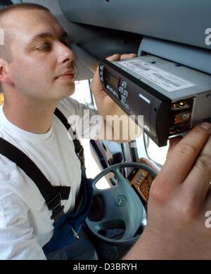 (dpa) - Mechanic Marcus Lorgi installs a On Board Unit for the electronic debiting of the truck toll in a lorry in Hamburg, 23 June 2003. The consortium Toll Collect, who operate the high tech system to levy the toll payments in Germany, have called back several thousand defect units. This informati Stock Photo