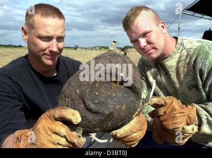 (dpa) - Captain Zeke Zukowsky (L) and Daniel Waldeop of the US army look at the helmet of a soldier who died during World War II, in Egeln, eastern Germany, 4 September 2003. The special unit of the US army is searching for the human remains of soldiers of a crashed bomber type B24. The bomber with  Stock Photo