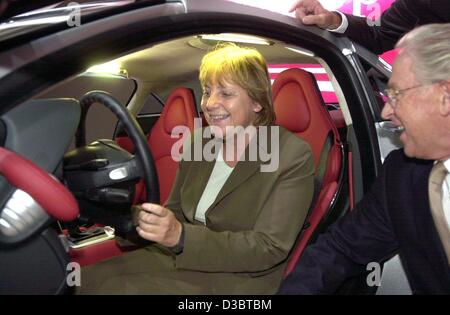 (dpa) - Angela Merkel, Chairwoman of the German opposition party CDU, sits at the wheel of a Mercedes SLR sports car, while Juergen Hubbert (R), CEO of DaimlerChrysler, explains the controls and instruments, during the international auto show IAA in Frankfurt, Germany, 15 September 2003. Merkel dema Stock Photo