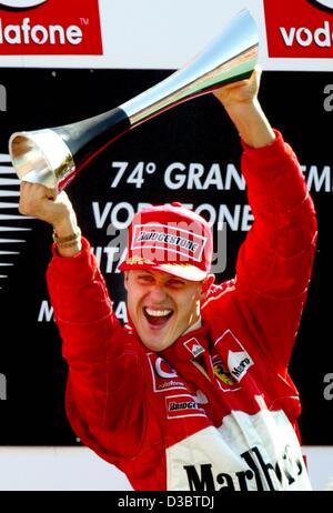 (dpa) - German formula one pilot Michael Schumacher of Ferrari cheers and waves his trophy after winning the Grand Prix of Italy in Monza, 14 September 2003. Schumacher now leads in the overall standings with 82 points.