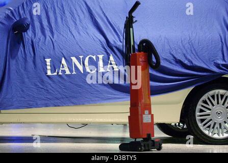 (dpa) - A hoover stands in front of a car which is covered with a canvas cover and has the company name 'Lancia' written on it at the stand of the Lancia car manmufacturer before the start of the 60th international car show IAA in Frankfurt Main, Germany, 8 September 2003. The number of sales has de Stock Photo